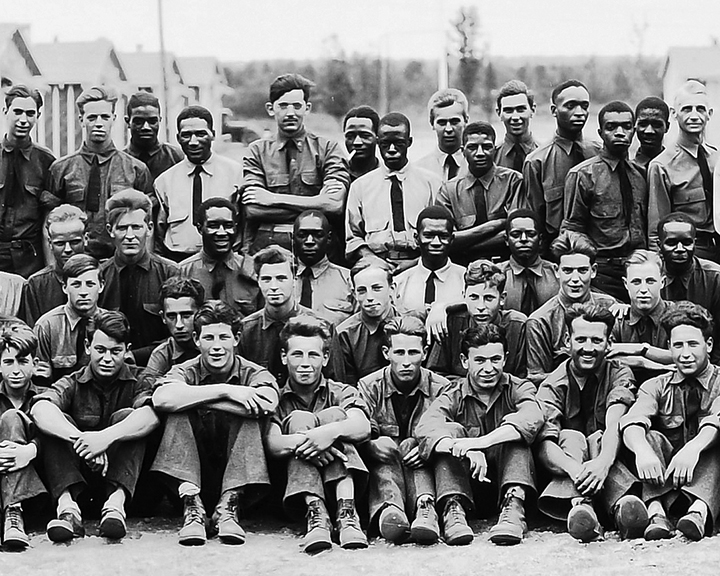 Group photograph of CCC enrollees posed in front of their camp barracks
